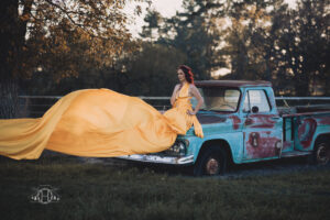 Women sitting in truck with yellow flying dress during photo session