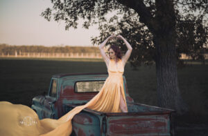 Women standing in back of truck with yellow dress