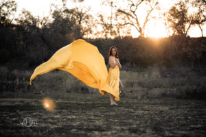 Sunset setting with model and long flowing yellow dress