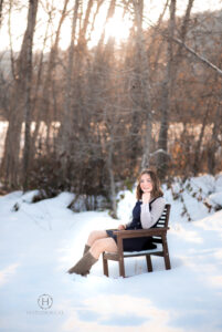 Girl sitting in chair during a snowy photo shoot for senior photographs